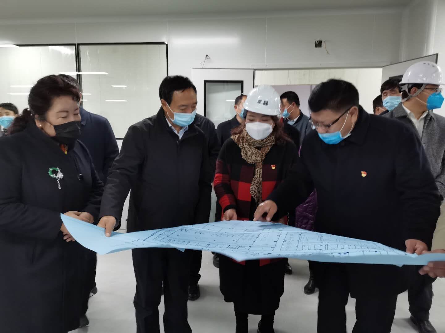 西藏自治區(qū)副主席江白（左二）等在工廠查看設(shè)計(jì)圖